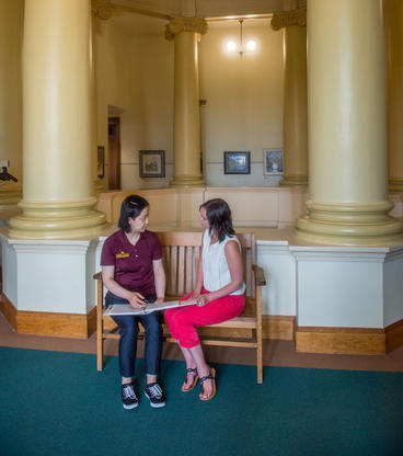 An Extension educator sits with a community partner in a government building